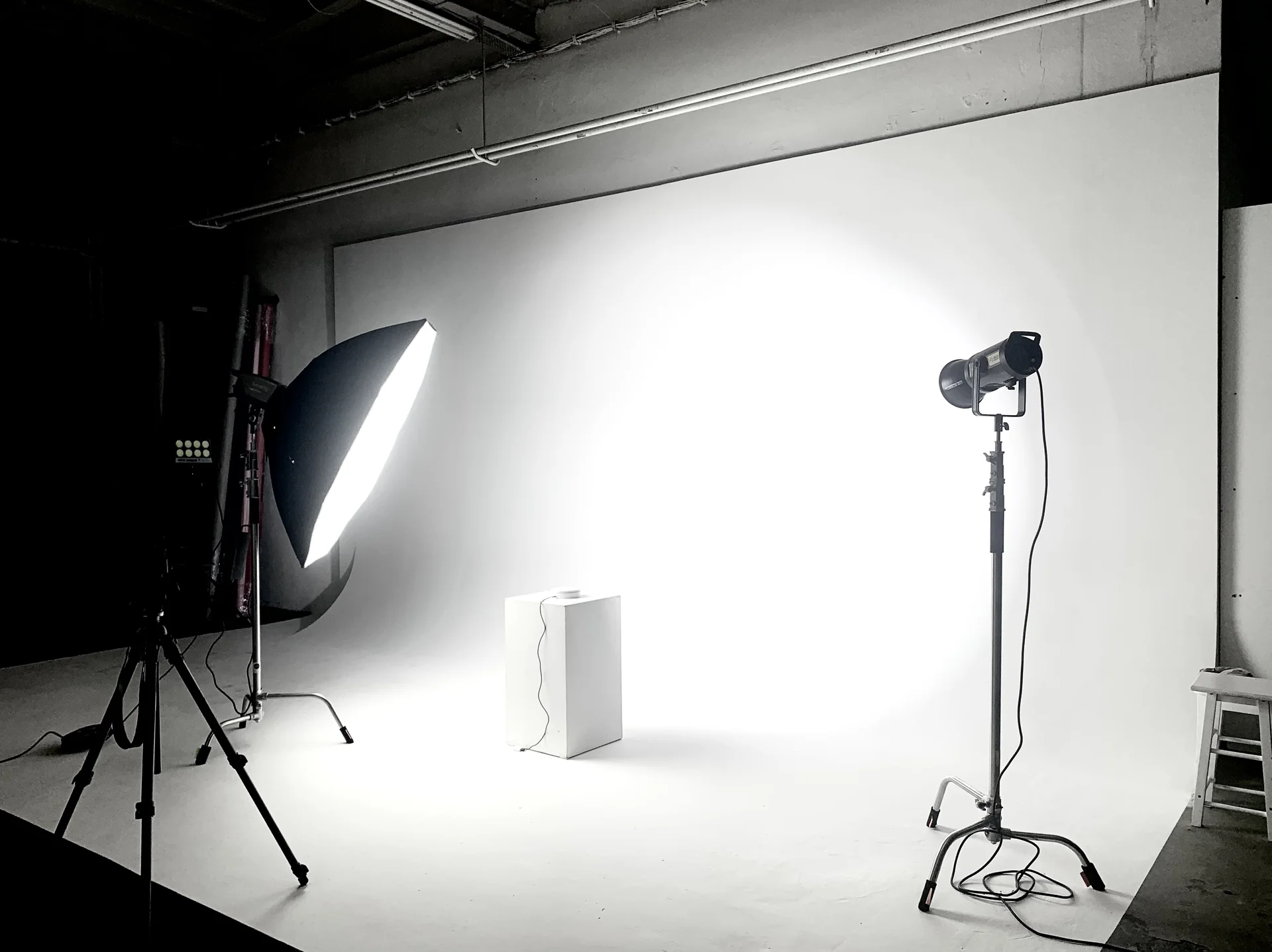 Professionelles Fotostudio Setup mit rotem Hintergrund, Beleuchtungsausrüstung und Stativ für Fotoshooting und Videoproduktion