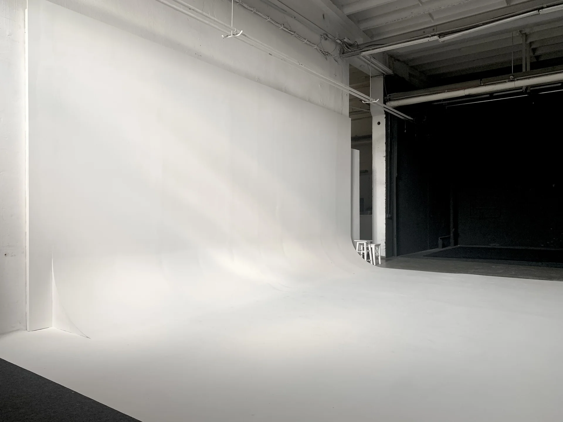 Professionelles Fotostudio Setup mit rotem Hintergrund, Beleuchtungsausrüstung und Stativ für Fotoshooting und Videoproduktion