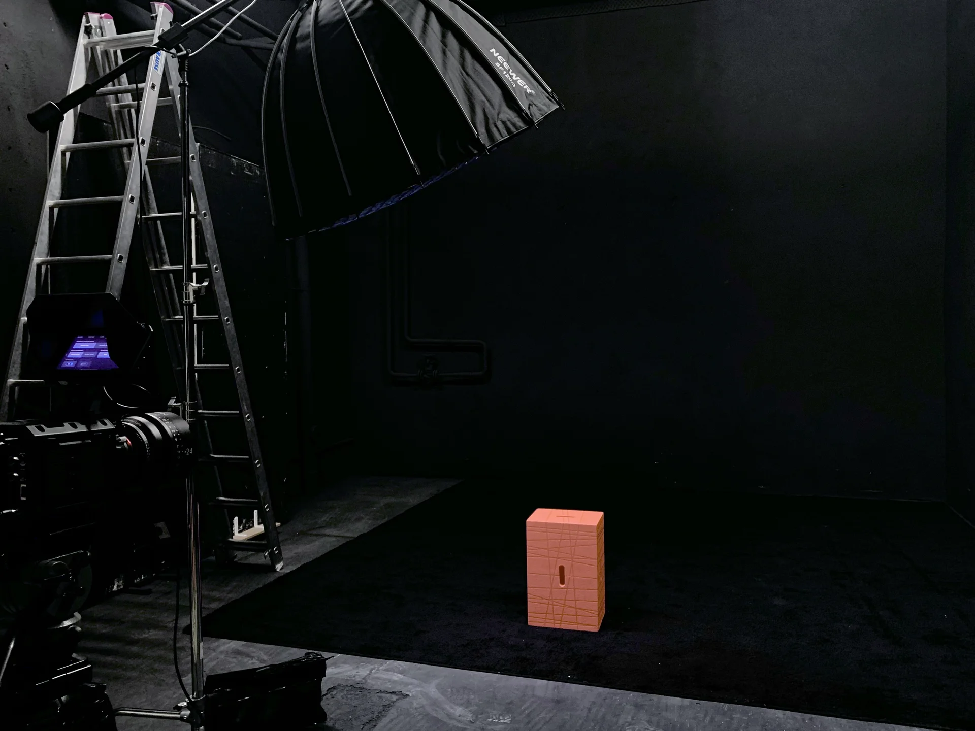 Schwarzer Raum. Professionelles Fotostudio-Setup mit Kamera, Scheinwerfern und Softbox-Beleuchtung auf dunklem Hintergrund.